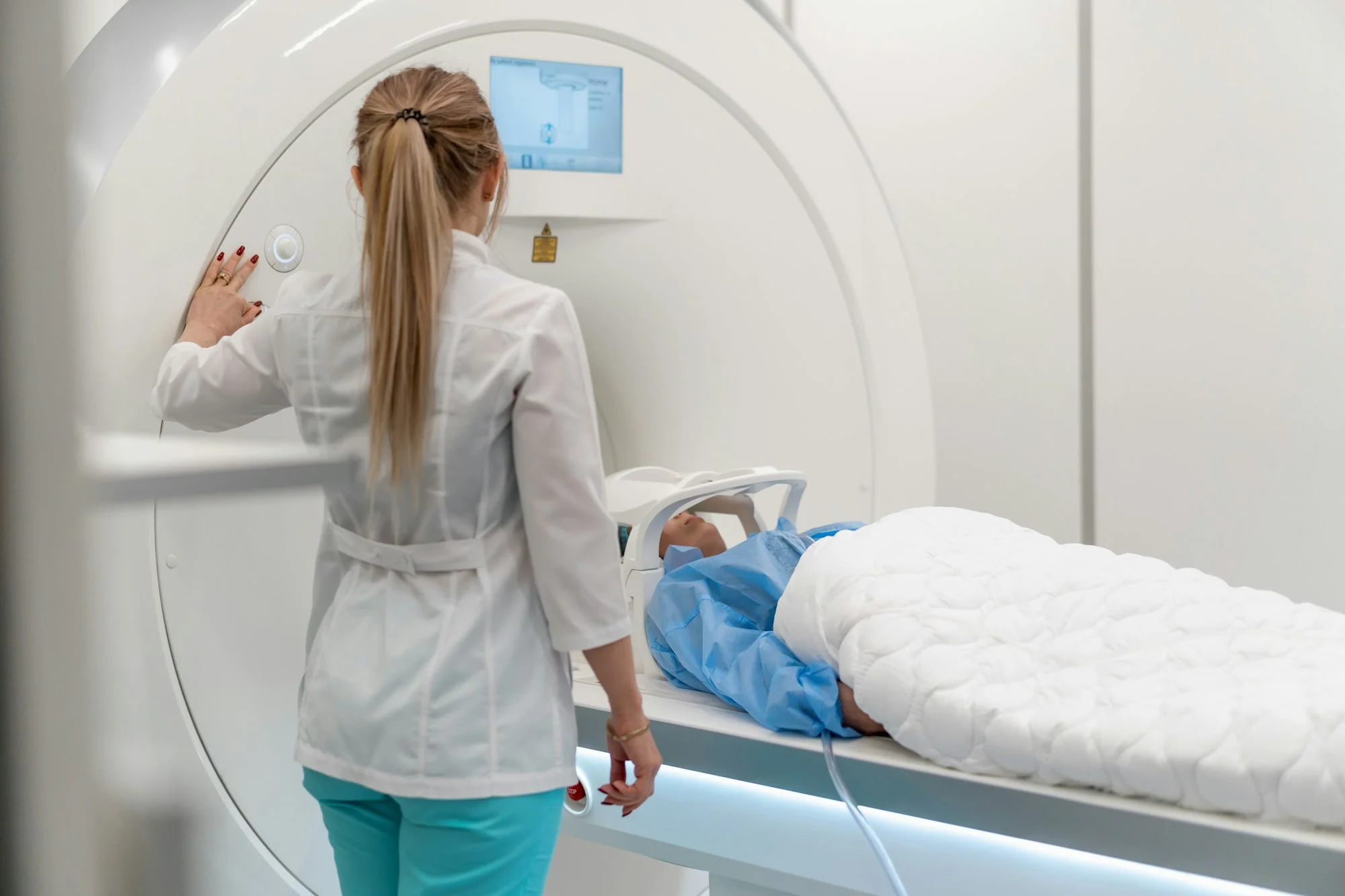 A professional radiologist in a medical clinic monitors patient magnetic resonance imaging procedure